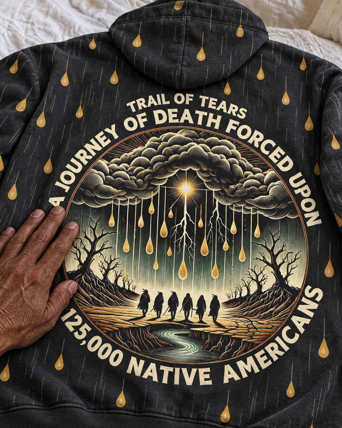 Hand resting on the back print of the Kiona Trail of Tears hoodie
