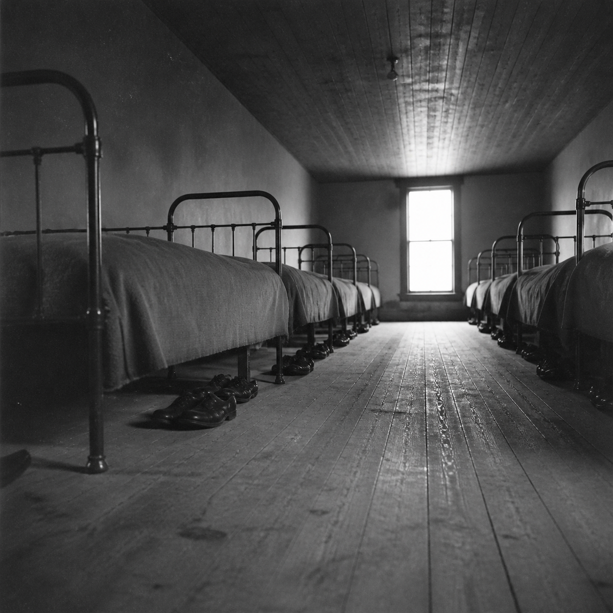 An empty Indian boarding school dormitory, around 1900