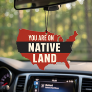 You Are On Native Land USA-map car air freshener hanging from a rear-view mirror